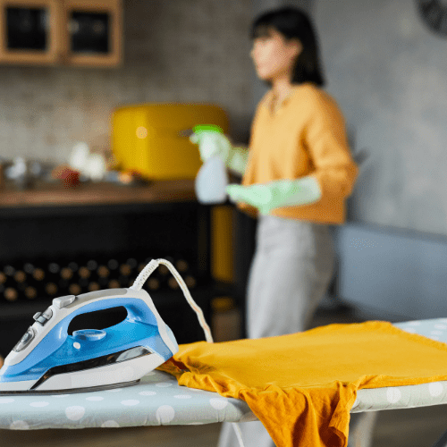 Haushaltshilfe bügelt Kleidung in moderner Wildeshausener Küche